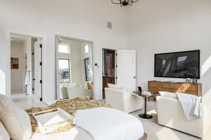 Carpeted bedroom featuring a high ceiling