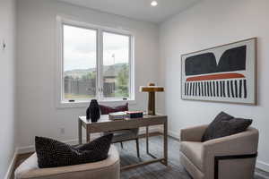 Home office with dark hardwood / wood-style flooring