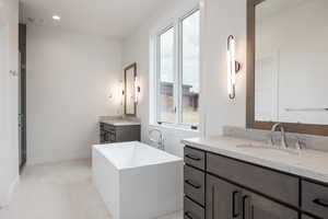 Bathroom featuring vanity and separate shower and tub