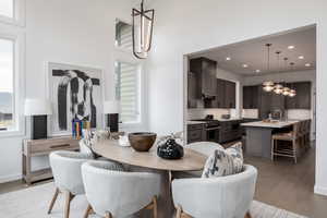 Dining area with sink, a high ceiling, and light hardwood / wood-style floors