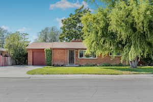 Single story home with a front yard and a garage