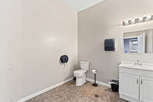 Bathroom 1 featuring paper towel dispenser, sink, toilet, and tile floors w/floor drain