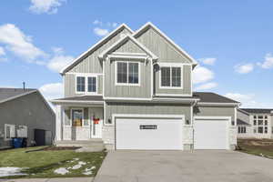 Craftsman house featuring a garage, a porch, and a front lawn