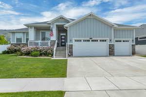 Craftsman inspired home featuring a front yard and a garage