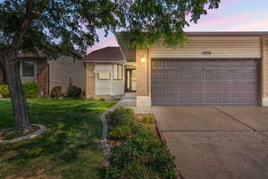 View of front facade with a garage and a yard