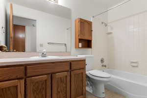 Full bathroom featuring tile patterned floors, toilet, tiled shower / bath combo, and vanity