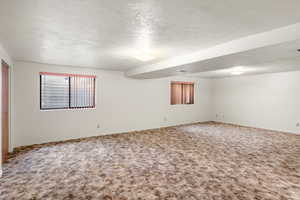 Unfurnished room featuring a textured ceiling and carpet floors