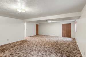 Unfurnished room with carpet flooring and a textured ceiling