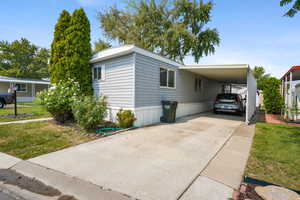 View of front of home featuring a carport and a front yard