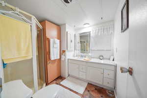 Bathroom with vanity, toilet, and a shower with door