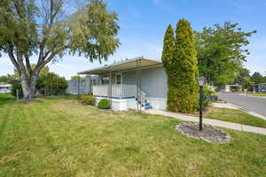 View of home's exterior featuring a yard and covered porch