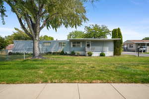 View of front of home with a front yard and covered porch