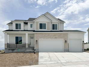 Craftsman inspired home with a garage, driveway, stone siding, and covered porch