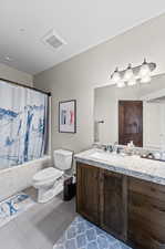 Full bathroom featuring tile patterned flooring, vanity, toilet, and shower / tub combo