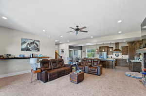 Living room with ceiling fan and light colored carpet