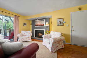 Living room with hardwood flooring, fireplace, and back porch