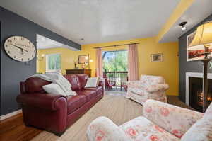 Living room with hardwood floors, a textured ceiling, sliding doors, and fireplace.