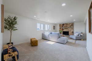 Living room featuring light carpet and a stone fireplace