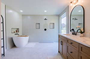 Bathroom with tile walls, independent shower and bath, and vanity