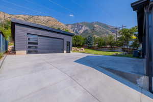 Exterior space with a yard, a garage, a mountain view, and an outbuilding