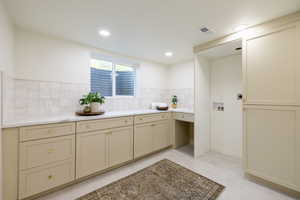 Bathroom with vanity, backsplash, and tile patterned flooring