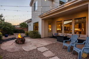 Patio terrace at dusk with an outdoor living space with a fire pit