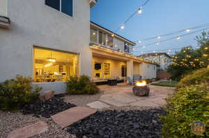 Rear view of house with a patio area and an outdoor living space with a fire pit