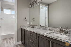 Bathroom 3 - with wood-type flooring, tiled shower / bath combo, and vanity