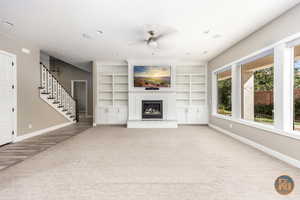 Unfurnished living room with ceiling fan and hardwood / wood-style flooring