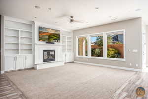 Unfurnished living room with ceiling fan, light wood-type flooring, and built in shelves & Surround Sound built in.