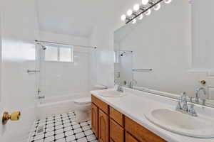 Full bathroom featuring double vanity, toilet, and tiled shower / bath combo.  Upstairs