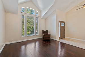 Entrance foyer featuring high vaulted ceiling, ceiling fan, and wood-type flooring