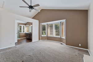 Primary Bedroom with large bath, double vanity, walk in shower, plantation shutters. Interior space featuring lofted ceiling, ceiling fan, and carpet