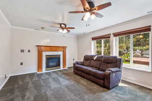 gathering room featuring ceiling fan, a tile fireplace, crown molding, and carpet floors, New windows in this room.