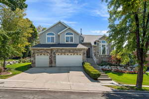 View of front property featuring a 3 car garage and a front yard