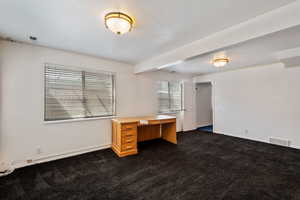 Lower level, was used as home office but could be play area or another gathering area. Carpeted with beamed ceiling