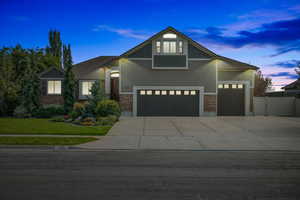 View of front of property with a yard and a garage