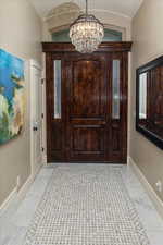 Entryway with an inviting chandelier and crown molding