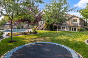 View of property's community featuring a lawn and a swimming pool