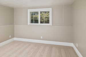 Carpeted spare room with a textured ceiling