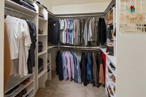 Master walk in closet with light colored carpet