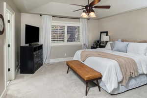 Master bedroom with light colored carpet and ceiling fan