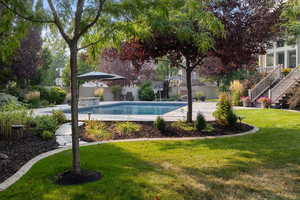 View of swimming pool featuring a lawn and a patio