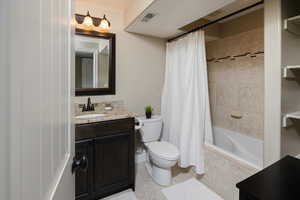 Master full bathroom featuring tile patterned flooring, vanity, toilet, and shower / tub combo