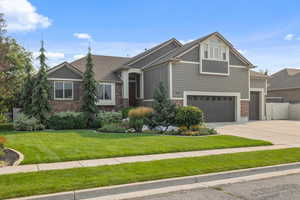 Craftsman-style house featuring a garage and a front lawn