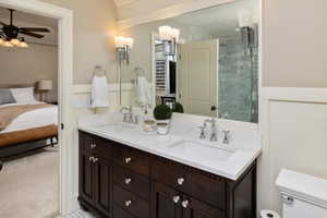 Master bathroom featuring vanity, ceiling fan, and an enclosed shower