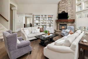 Living room featuring ornate columns, dark hardwood / wood-style flooring, and a fireplace