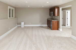 Kitchen featuring appliances with stainless steel finishes, light colored carpet, a textured ceiling, and sink