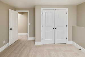 Unfurnished bedroom with a closet and light colored carpet