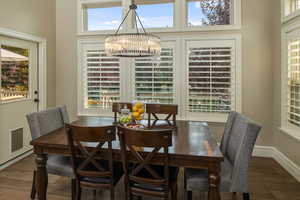 Dining space featuring dark wood-type flooring and an inviting chandelier